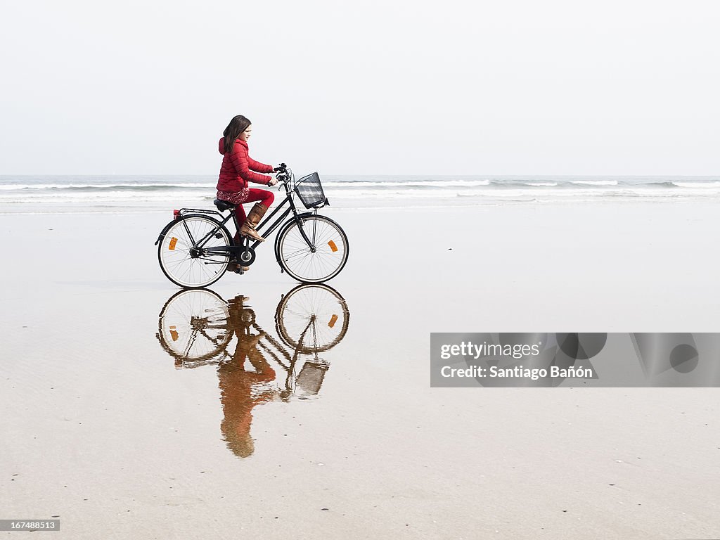 Girl riding bycicle at the beach