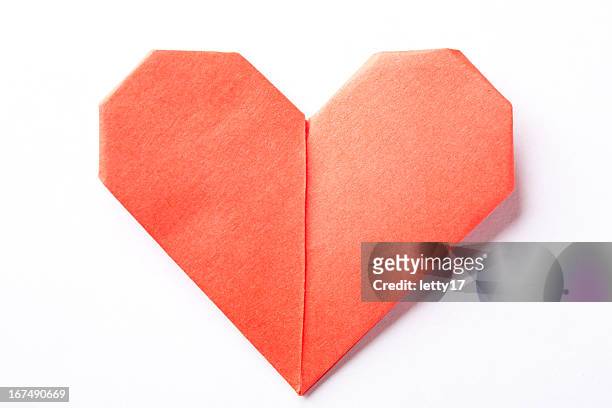 a red origami heart on a white background - origami stockfoto's en -beelden