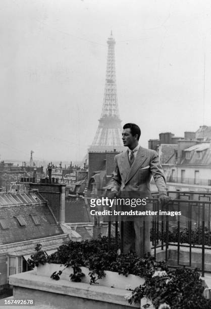 The US-american actor Robert Taylor at his hotel balcony in Paris. In the background: The Eiffel Tower. 1937. Photograph. Der US-amerikanische...