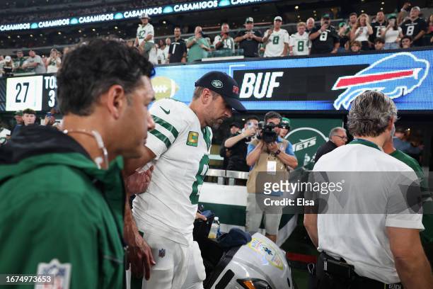 Quarterback Aaron Rodgers of the New York Jets is helped off the field after an injury during the first quarter of the NFL game against the Buffalo...
