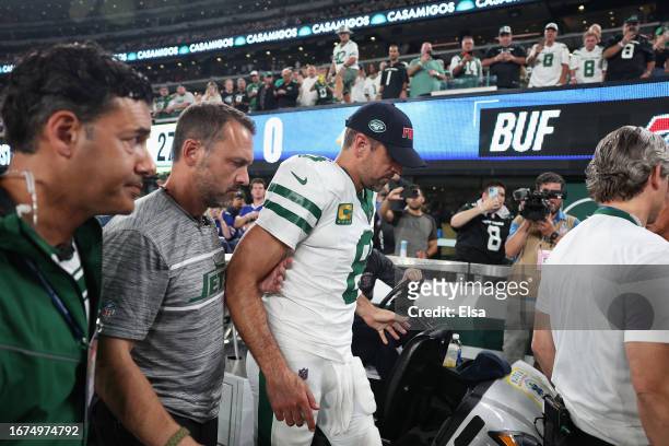 Quarterback Aaron Rodgers of the New York Jets is helped off the field after an injury during the first quarter of the NFL game against the Buffalo...