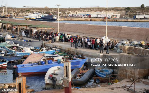Migrants wait at the port after arriving on the Italian island of Lampedusa, on September 18, 2023. Italy was set September 18 to unveil tough rules...