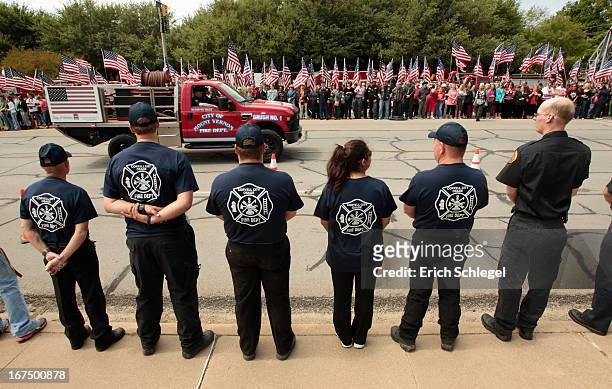 Members of the Corvell City and Osage Volunteer Fire Department watch as fire departments from around Texas pay their respects during a parade for...