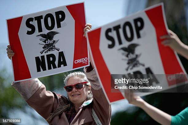 Anti-gun violence demonstrators, including Robin Diener , hold signs condeming the National Rifle Association during a protest in McPhearson Square...