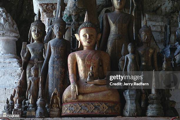 Detail of Buddha statues of all sizes lined up by the thousand in their caves over the Mekong River..