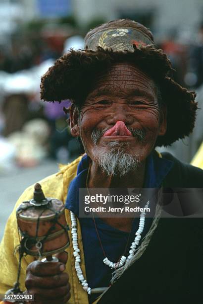 Tibetan Buddhist touches his nose with the tip of his tongue in a traditional Tibetan greeting, while circumambulating the Jokhang Temple in Lhasa....