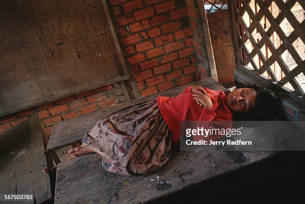 Girl stares off into space, nearly comatose, in an empty classroom at the Cambodian Light Children Association. She was brought to the orphanage a...