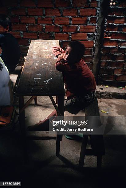 Chan Pau sits through a math class at the Cambodian Light Children Association without a textbook, pen or paper. He is one of dozens of local kids...