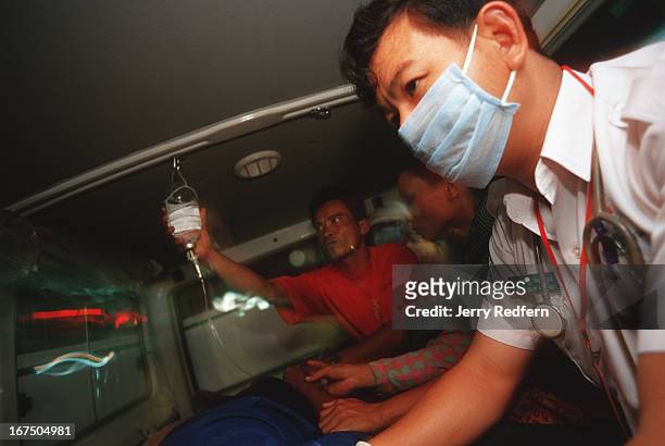 Ser Hong, right, monitors a man's vital signs as he is transported from a village clinic to Calmette Hospital along with his family. S.A.M.U., short...