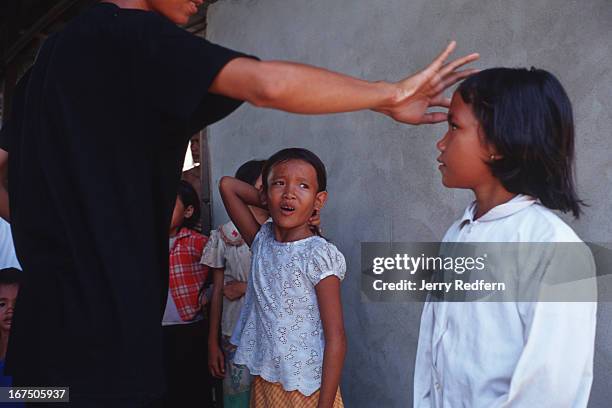 Children from the surrounding neighborhood are lined up to have registration pictures taken at the Cambodian Light Children Association. The kids...