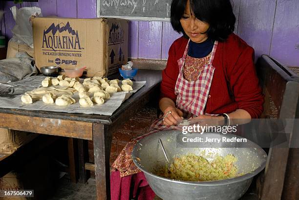 Woman makes vegetarian momos - Tibetan dumplings - at the Hot Stimulating Cafe. The dumplings will later be cooked by steaming them..