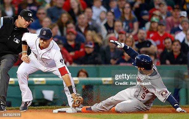 Marwin Gonzalez of the Houston Astros steals third base as Will Middlebrooks of the Boston Red Sox is late with the tag in the 3rd inning at Fenway...