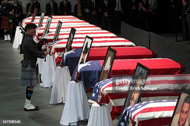 James McNeely of Texas Task Force One plays the bagpipes in front of the 12 caskets at the West memorial service held at Baylor University April 25,...