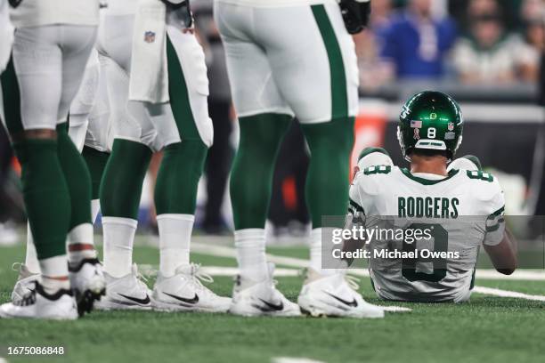 Aaron Rodgers of the New York Jets sits down after an apparent injury after getting sacked by Leonard Floyd of the Buffalo Bills prior to a game at...