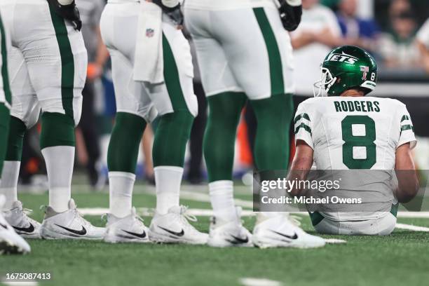 Aaron Rodgers of the New York Jets sits down after an apparent injury after getting sacked by Leonard Floyd of the Buffalo Bills prior to a game at...