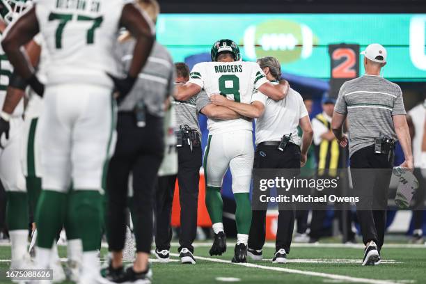 Aaron Rodgers of the New York Jets is helped off the field for an apparent injury during a game against the Buffalo Bills at MetLife Stadium on...