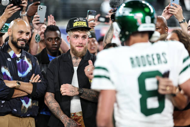 Youtuber and Boxer Jake Paul chats with Aaron Rodgers of the New York Jets prior to a game against the Buffalo Bills at MetLife Stadium on September...