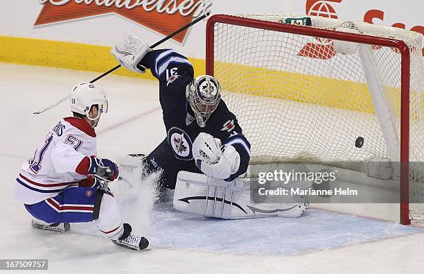 Ondrej Pavelec of the Winnipeg Jets blocks shot on goal by David Desharnais of the Montreal Canadiens during first period NHL action on April 25,...