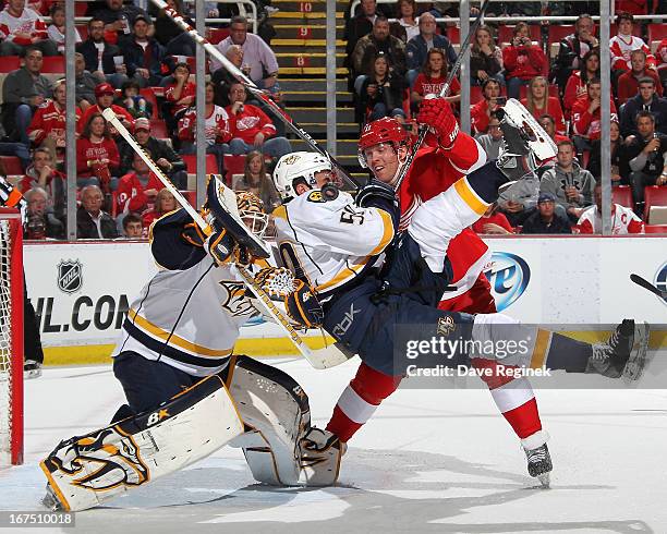 Goalie Chris Mason of the Nashville Predators tries to locate the puck as teamate Roman Josi gets taken out by Daniel Cleary of the Detroit Red Wings...