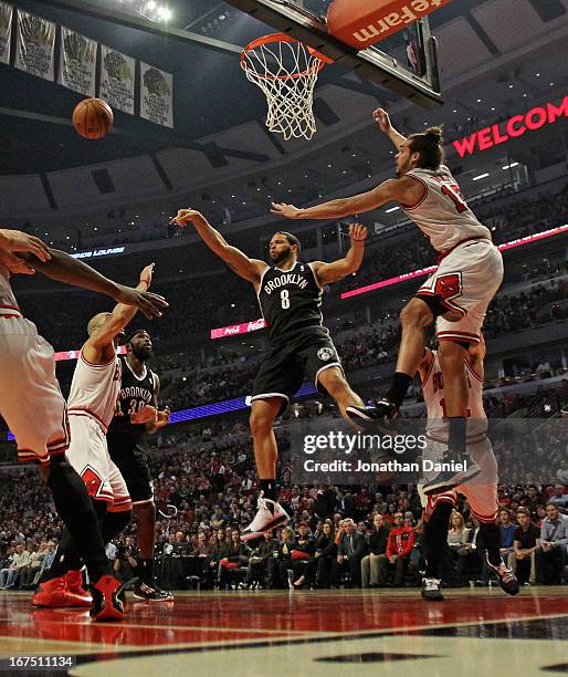 Deron Williams of the Brooklyn Nets passes between Carlos Boozer and Joakim Noah of the Chicago Bulls in Game Three of the Eastern Conference...