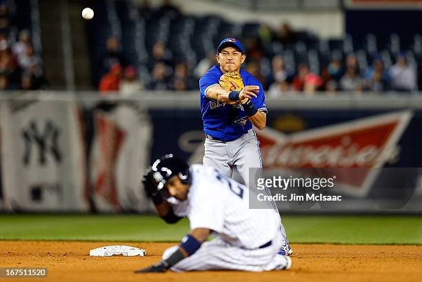 Munenori Kawasaki of the Toronto Blue Jays throws to first base to complete an eighth inning ending double play after forcing out Eduardo Nunez of...