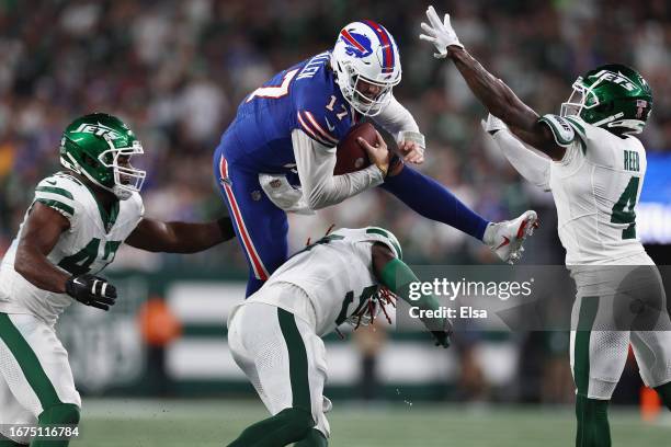 Quarterback Josh Allen of the Buffalo Bills scrambles with the football against Bryce Huff and D.J. Reed of the New York Jets during the second...