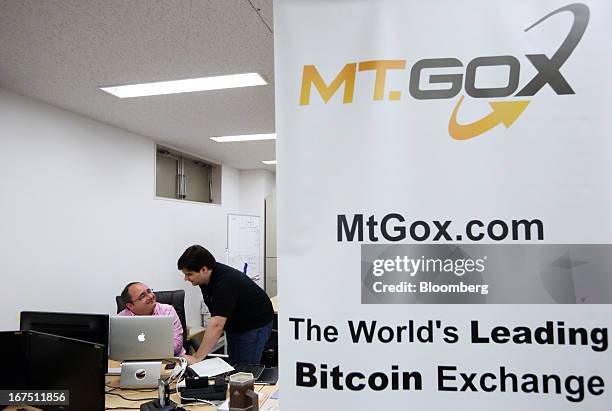 Mark Karpeles, chief executive officer of Tibanne Co., right, speaks to an employee in the office operating the Mt.Gox K.K. Bitcoin exchange in...