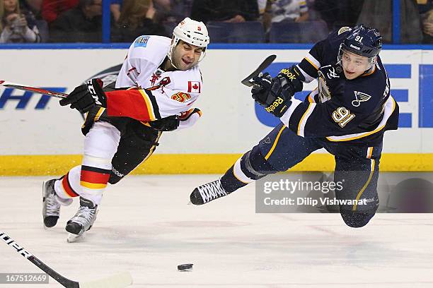 Vladimir Tarasenko of the St. Louis Blues takes a shot on goal as he fall to the ice against Mark Giordano of the Calgary Flames during the third...