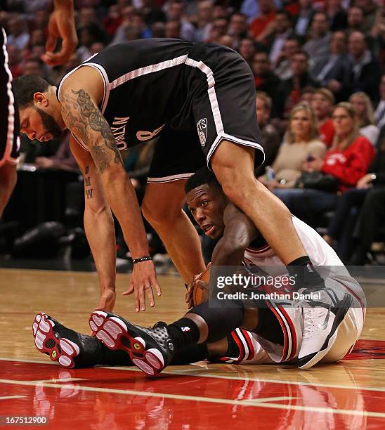 Nate Robinson of the Chicago Bulls ends up under Deron Williams of the Brooklyn Nets after chasing down a loose ball in Game Three of the Eastern...