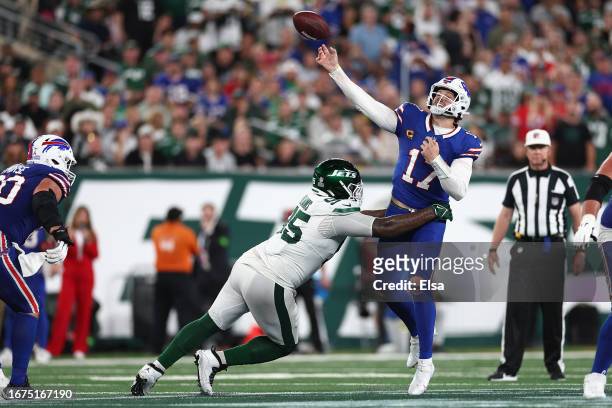 Quarterback Josh Allen of the Buffalo Bills throws an interception on a deep pass under pressure from defensive tackle Quinnen Williams of the New...