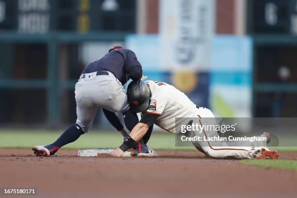 Base runner Mitch Haniger of the San Francisco Giants slides into second base ahead of the tag by Andres Gimenez of the Cleveland Guardians in the...