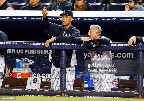 Derek Jeter and first base coach Mick Kelleher of the New York Yankees look on in the fourth inning against the Toronto Blue Jays at Yankee Stadium...