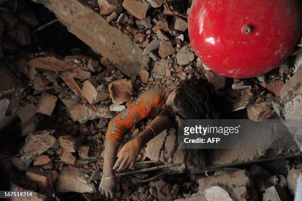 Bangladeshi garment worker lies crushed under the rubble 48 hours after the Rana Plaza garment building collapsed in Savar, on the outskirts of...