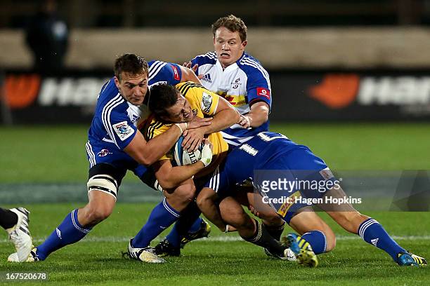 Tim Bateman of the Hurricanes is tackled by Ryndhardt Elstadt of the Stormers during the round 11 Super Rugby match between the Hurricanes and the...