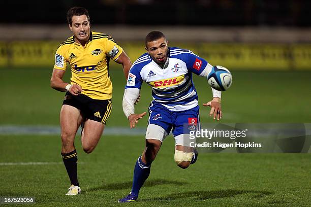 Bryan Habana of the Stormers chases a loose ball under pressure from Tim Bateman of the Hurricanes during the round 11 Super Rugby match between the...
