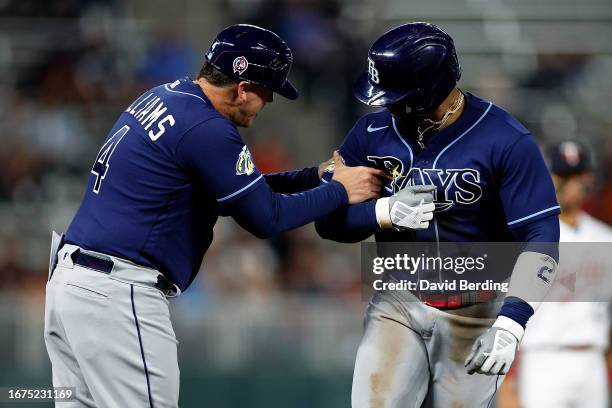 Yandy Diaz of the Tampa Bay Rays celebrates his solo home run with third base coach Brady Williams as he rounds the bases against the Minnesota Twins...