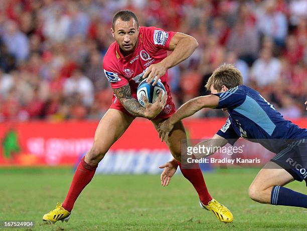 Quade Cooper of the Reds looks to take on the defence during the round 11 Super Rugby match between the Reds and the Blues at Suncorp Stadium on...