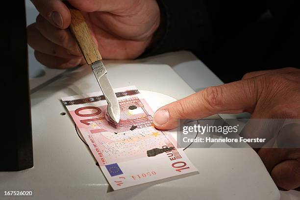 Frank Herzog inspects burnt money at the analysis lab of the German Bundesbank during a demonstration for the media on April 26, 2013 in Mainz,...