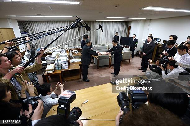 Osamu Shinobe, president and chief executive officer of All Nippon Airways Co. , center right, receives a technical circular directive document from...