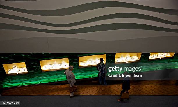 Visitors pass a display of wristwatches at the Rolex Group stand during the Baselworld watch fair in Basel, Switzerland, on Thursday, April 25, 2013....