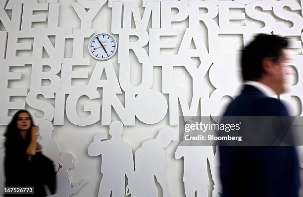 Visitors pass the Mondaine Watch Ltd. Booth during the Baselworld watch fair in Basel, Switzerland, on Thursday, April 25, 2013. The annual fair...