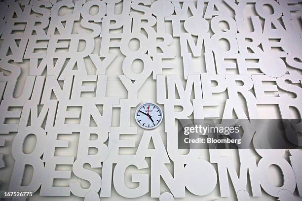Clock sits in the center of a wall display at the Mondaine Watch Ltd. Booth during the Baselworld watch fair in Basel, Switzerland, on Thursday,...