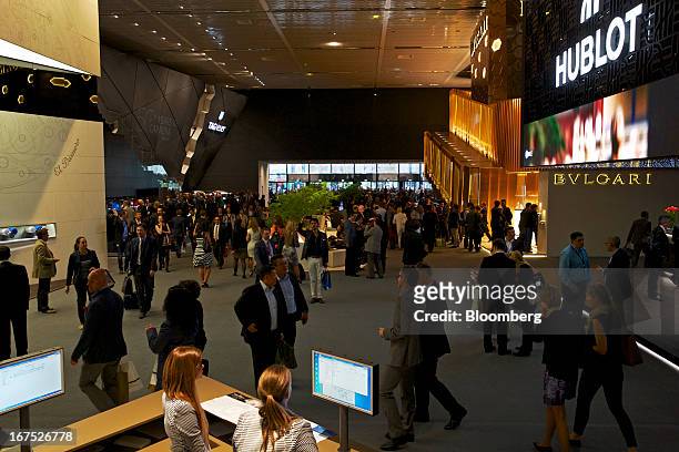 Visitors pass display booths for Hublot, Bulgari and Tag Heuer during the Baselworld watch fair in Basel, Switzerland, on Thursday, April 25, 2013....