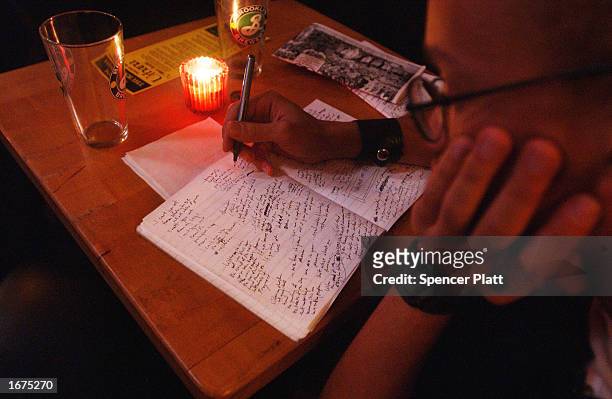 Poet writes before a poetry performance at the Bowery Poetry Club December 6, 2002 in New York City. The Bowery Poetry Club, which offers nightly...