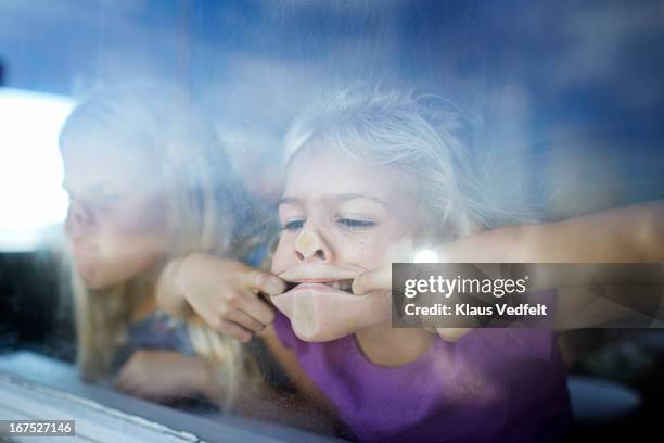 girls making funny faces behind window - suga bildbanksfoton och bilder