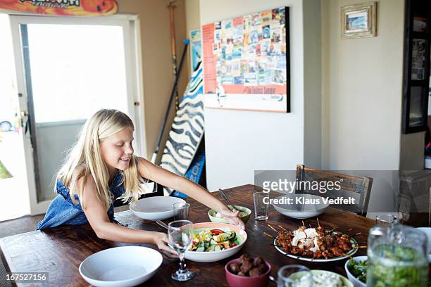 girl putting salad bowl on dinner table - setting the table stock pictures, royalty-free photos & images
