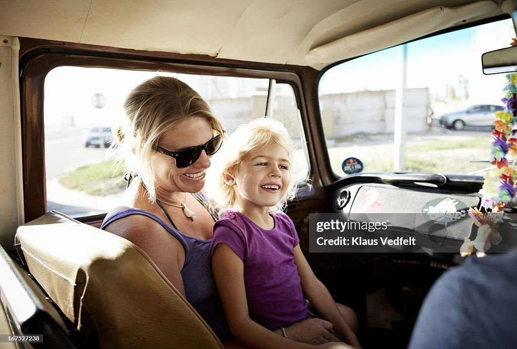 Mother and daughter laughing sitting in car