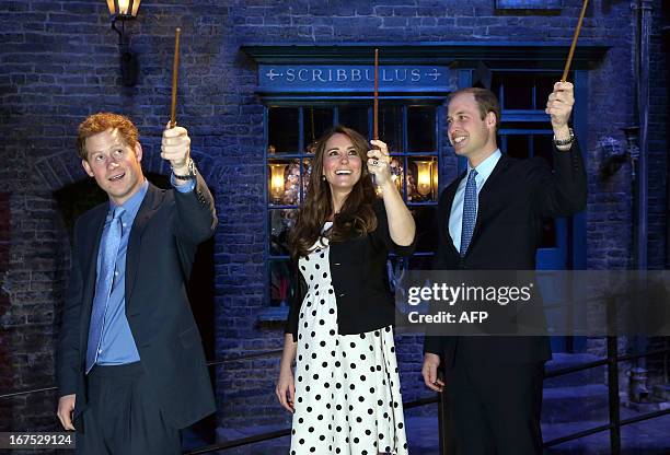 Britain's Prince William , Duke of Cambridge, his wife Catherine, Duchess of Cambridge, and brother Prince Harry raise their wands on the set used to...