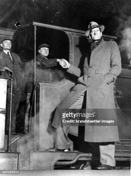 The tallest man in the world shakes hand an engine driver in Waterloo Station/London. December 18th 1931. Photograph. Der größte Mensch der Welt...