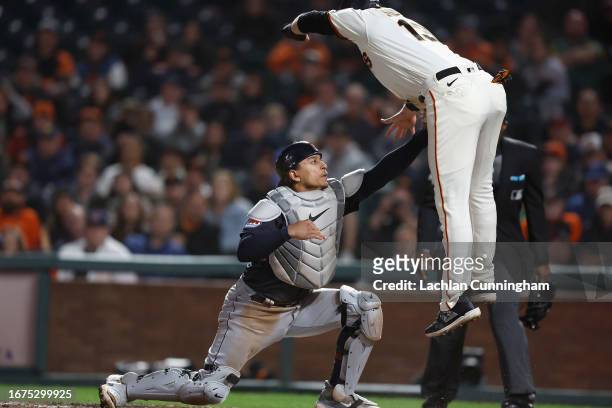 Base runner Austin Slater of the San Francisco Giants is tagged out at home plate by catcher Bo Naylor of the Cleveland Guardians in the bottom of...